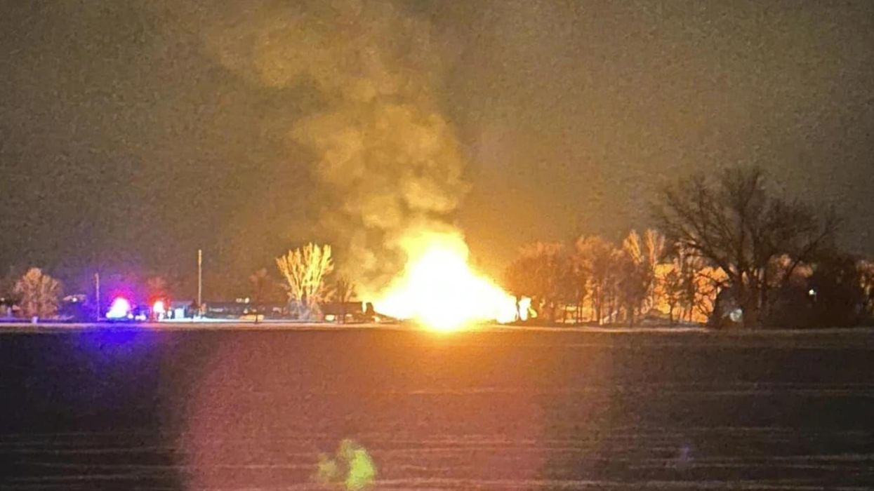 A Raymond, Minnesota resident takes a photo of the fiery BNSF train derailment