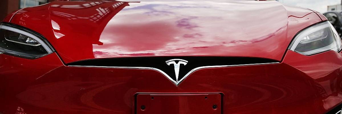 A red Tesla from the front.