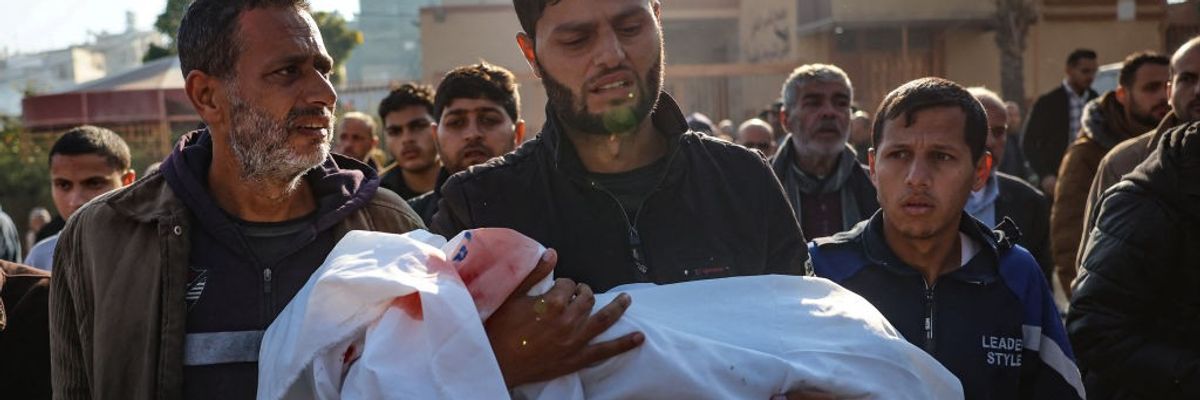 A relative carries the body of a child at a Gaza hospital