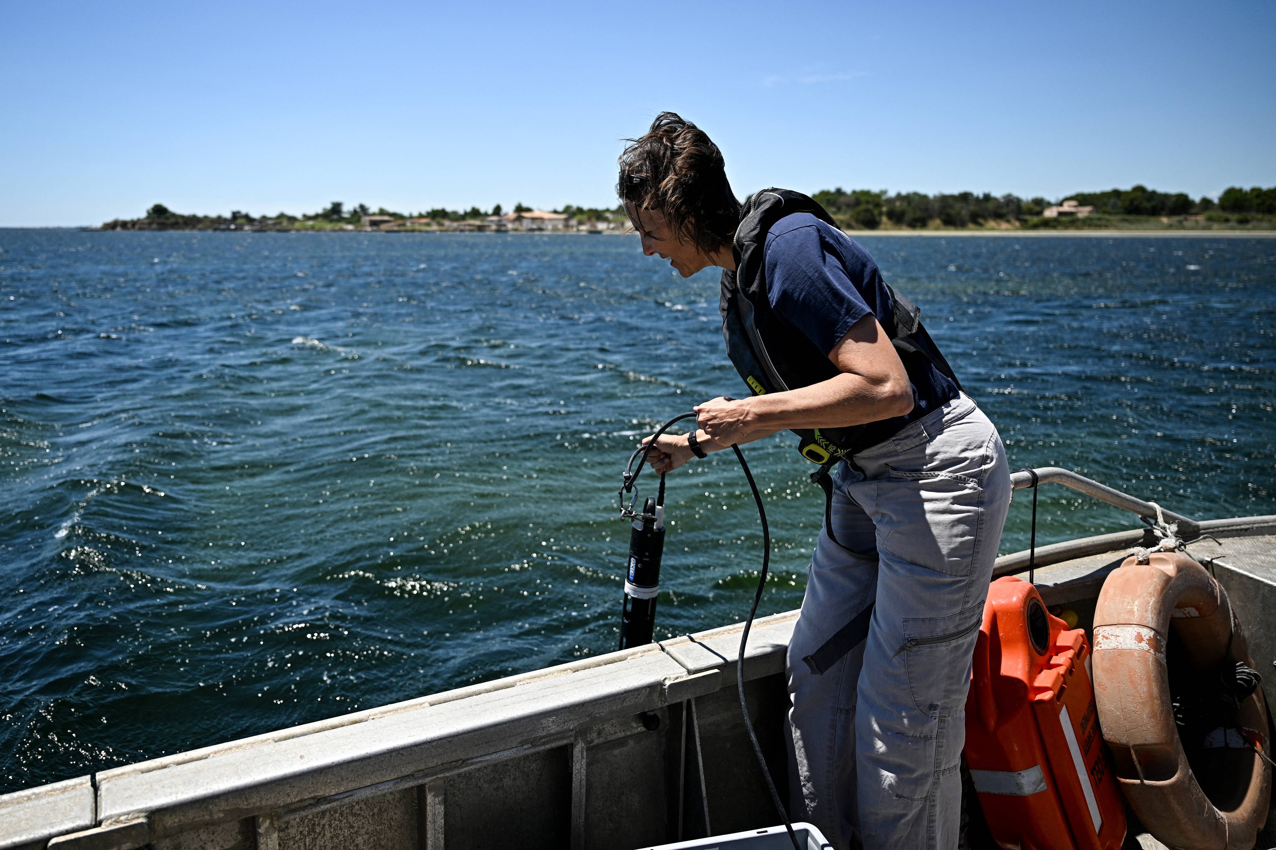 A researcher measures ocean temperatures and oxygen levels.