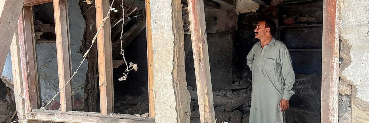 A resident looks at his damaged house after cross-border shelling along the Line of Control
