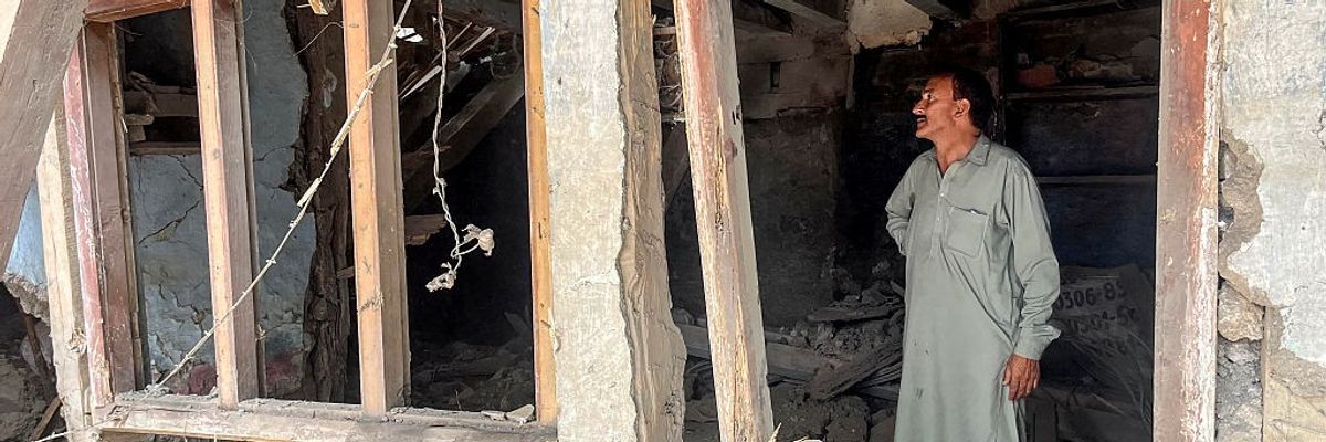 A resident looks at his damaged house after cross-border shelling along the Line of Control