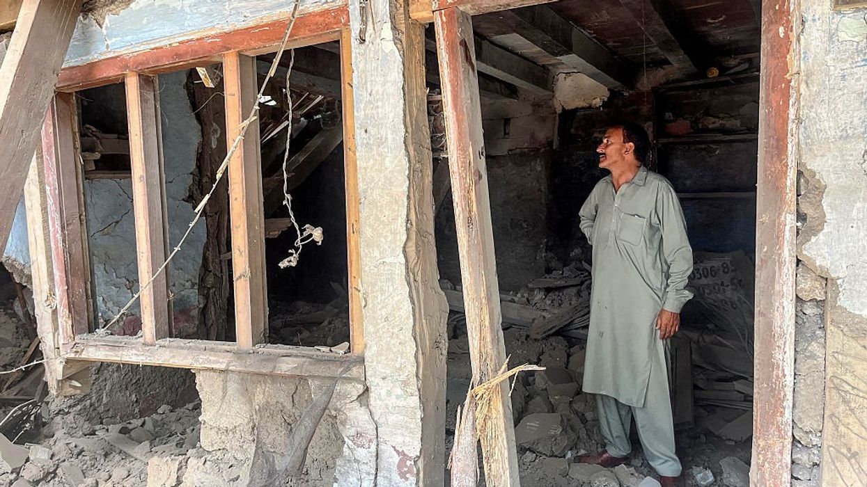 A resident looks at his damaged house after cross-border shelling along the Line of Control