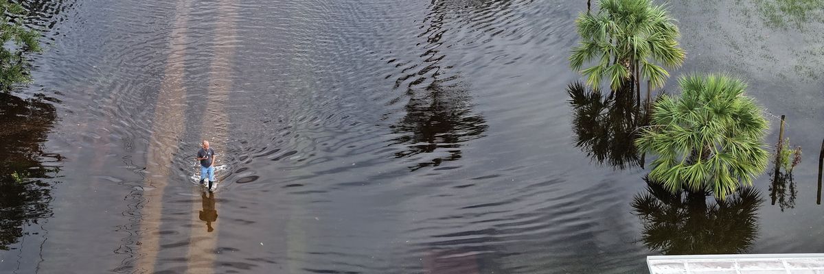 A resident walks through flood waters that inundated a neighborhood