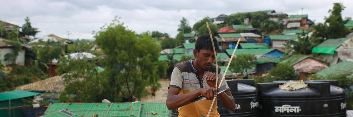 ​A Rohingya man makes a bamboo fence for a house at the Kutupalong refugee camp in Cox's Bazar, Bangladesh on August 26, 2020.