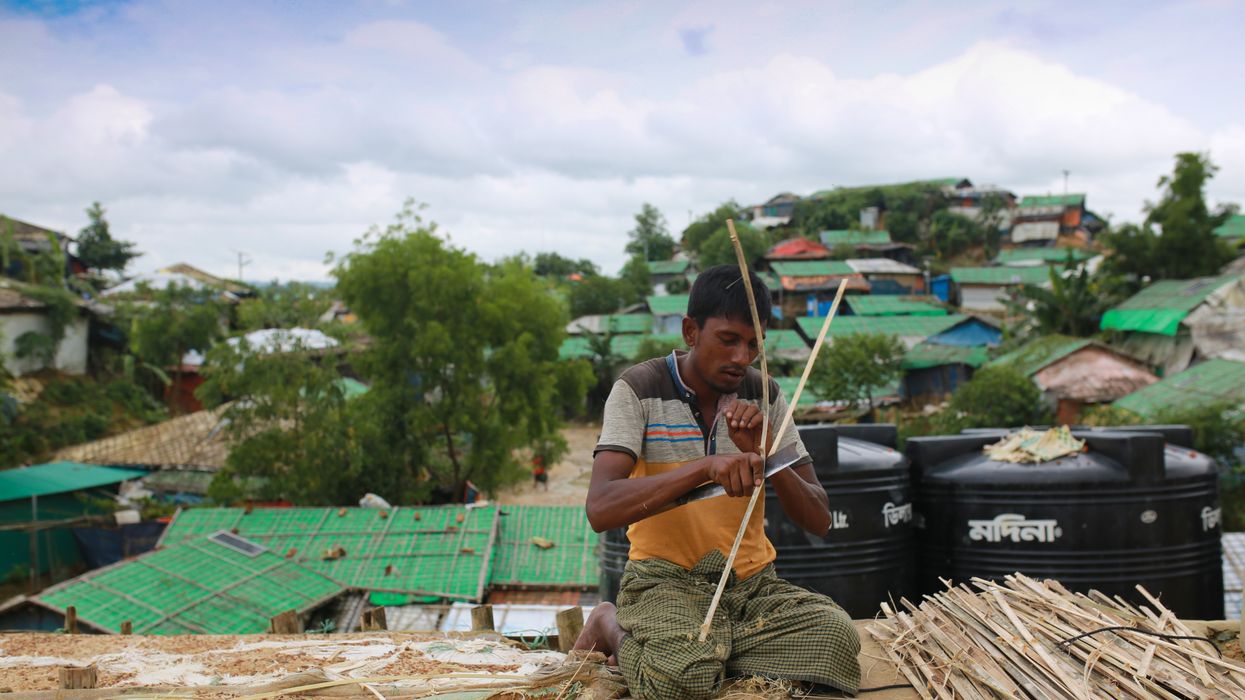 A Rohingya man makes a bamboo fence for a house at the Kutupalong refugee camp in Cox's Bazar, Bangladesh on August 26, 2020.