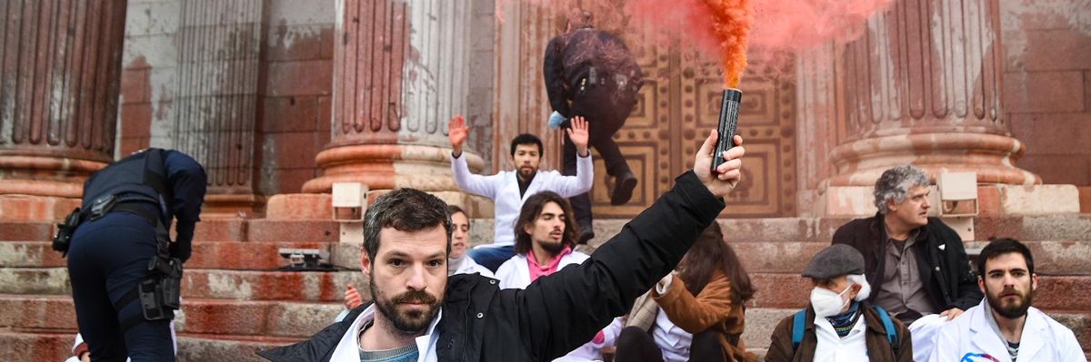 A scientist lifts a red smoke bomb into the air.