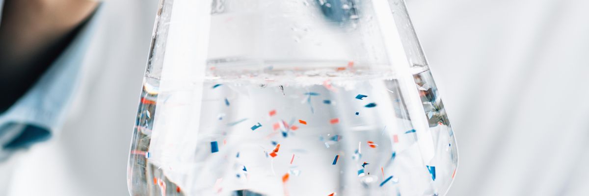 A scientist observes microplastics in a lab.