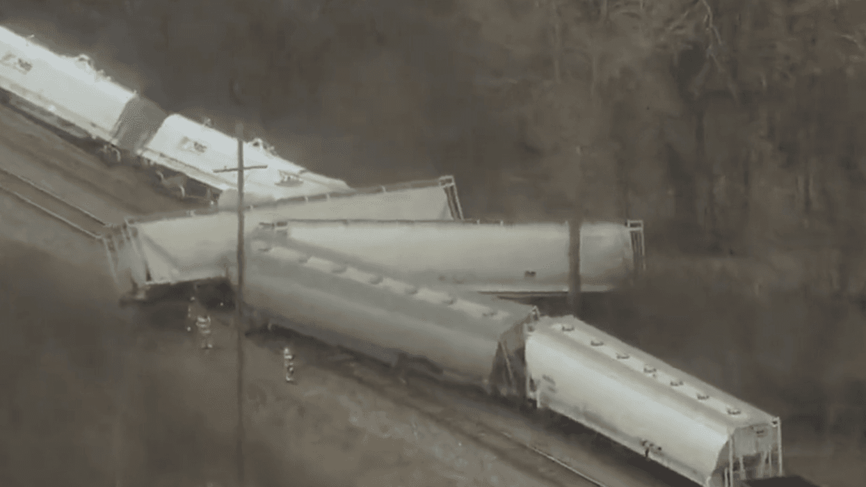 A screenshot of video footage shows a derailed train in Van Buren Township
