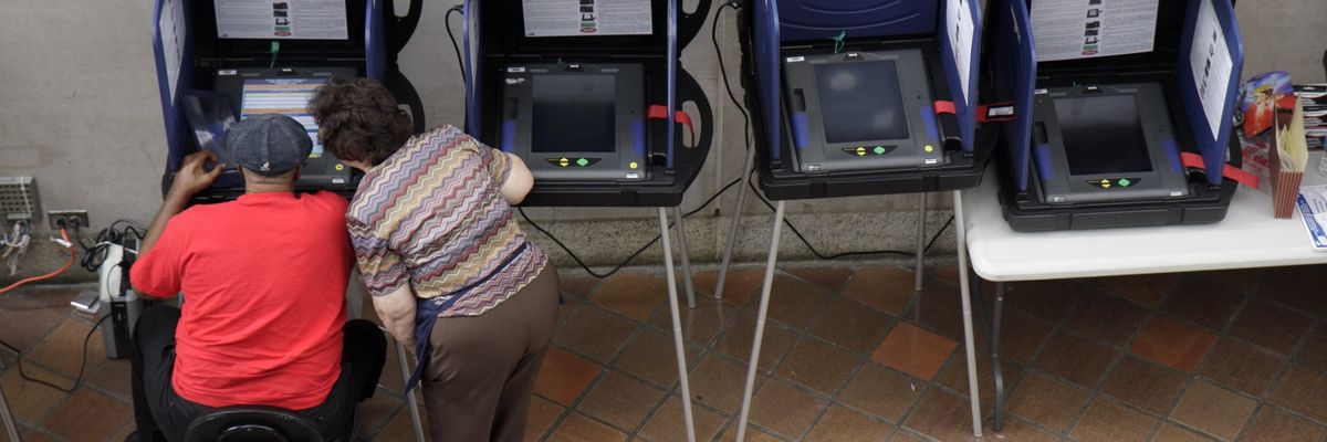 A senior woman assisting a man in an electric scooter at the voting machines for early voting at the Stephen P. Clark Government Center.