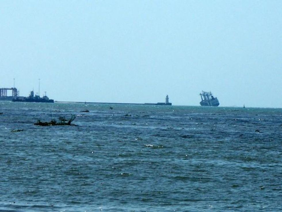 A ship tilts precariously at the mouth of the Colombo harbour as tsunami waves hit the southwestern coast of Sri Lanka on Dec. 26, 2004. (Photo: Amantha Perera/IPS)