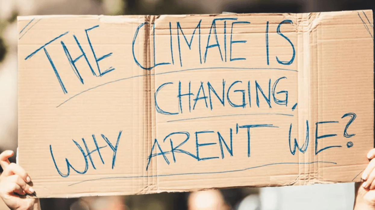 A sign at a protest reads, "The climate is changing, why aren't we?"