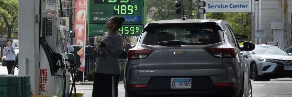 A sign displays gas prices at a gas station