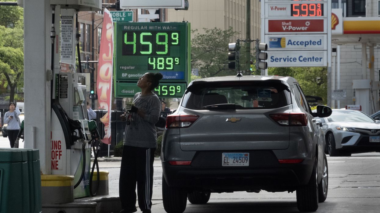 A sign displays gas prices at a gas station