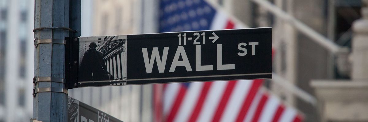 A sign for Wall Street and American flags in New York, U.S.. 