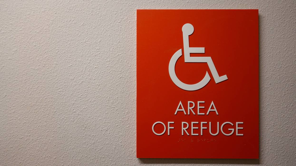 A sign in a hallway in an apartment complex that says Area of Refuge
