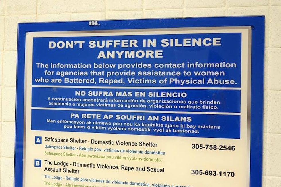 A sign on a wall that provides contact information to help victims of battering, rape and other physical abuse.