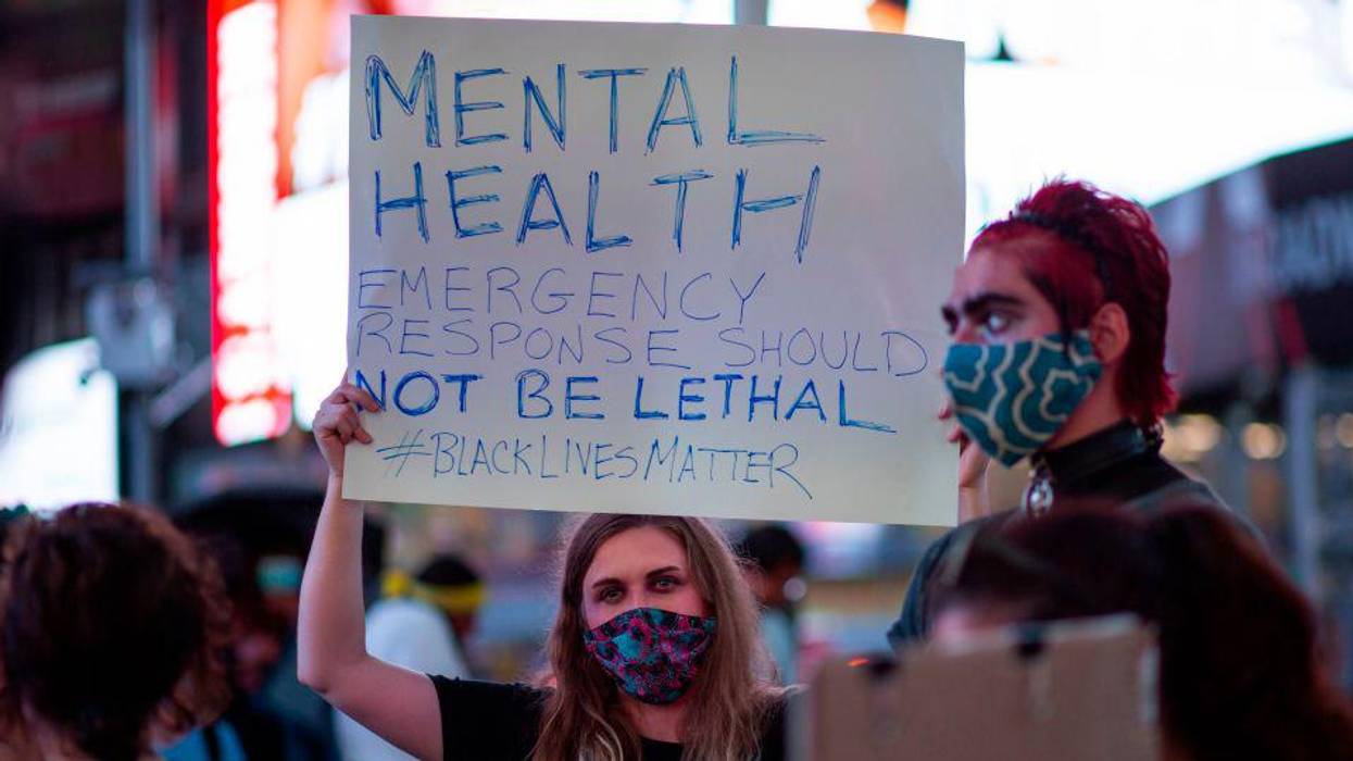 A sign protests lethal responses to mental health emergencies.