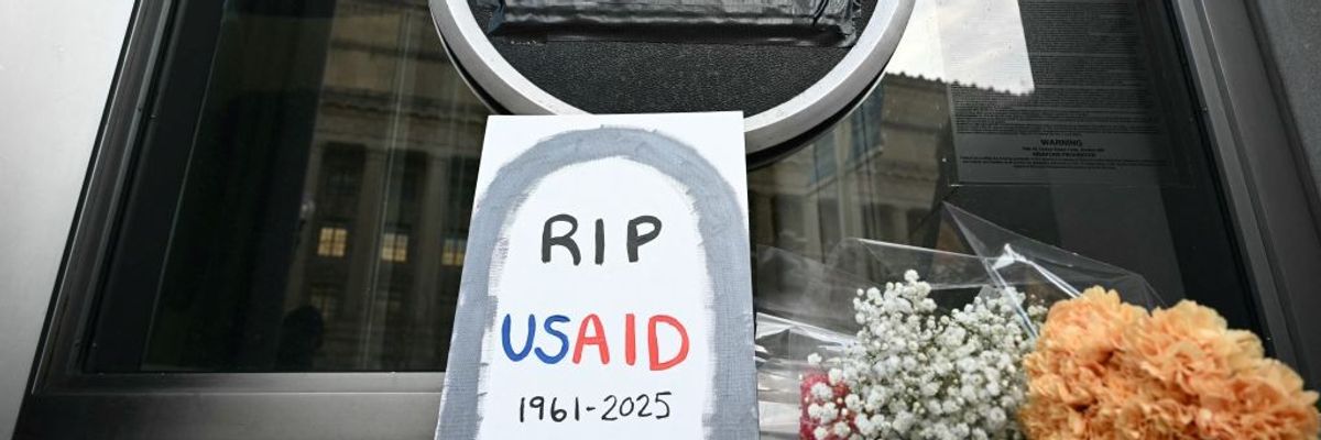 A sign reading "RIP USAID" is seen outside the agency's headquarters