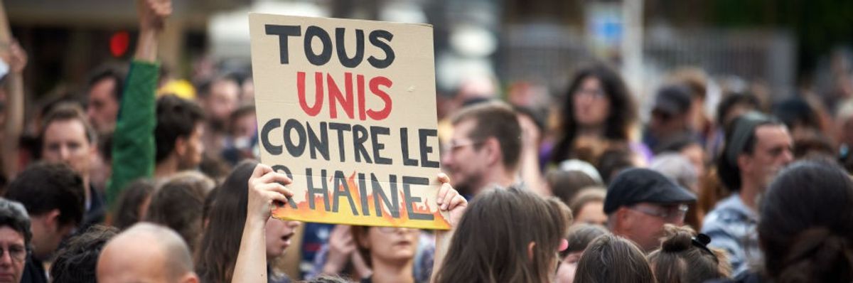 A sign reads "everyone unite against hate" at an anti-far-right rally in France