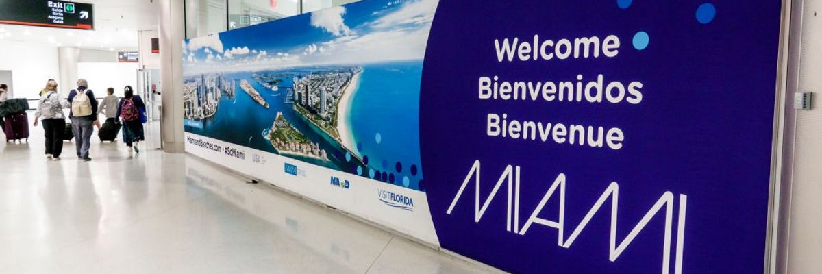 A sign welcomes visitors to Miami International Airport in three languages