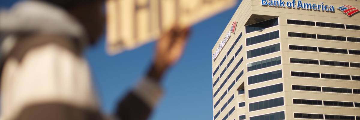 A signed that reads "I am 99%" outside a Bank of America building