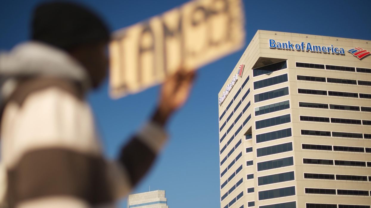 A signed that reads "I am 99%" outside a Bank of America building
