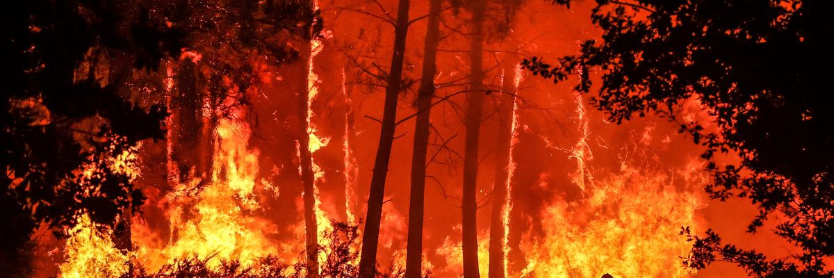 A silhouette is seen in front of flames at a wildfire near Belin-Beliet, southwestern France, overnight on August 11, 2022.