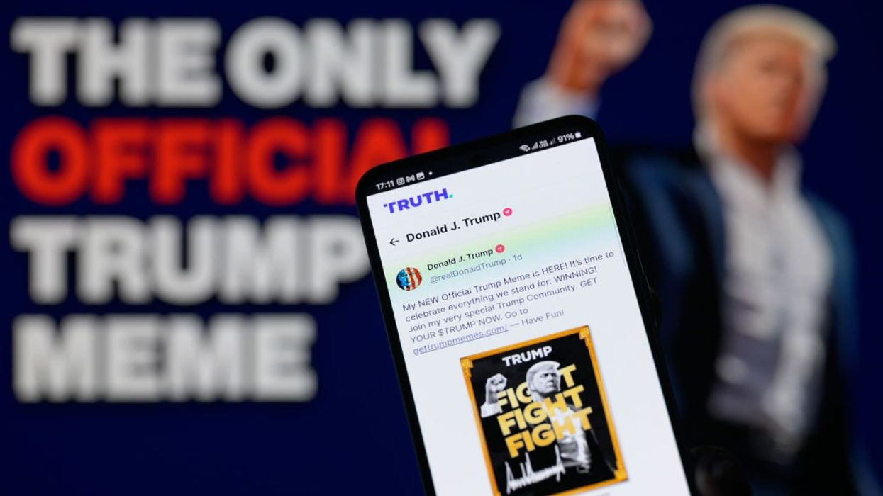 A smartphone displays a post from U.S. President-elect Donald Trump's Truth account announcing the $TRUMP