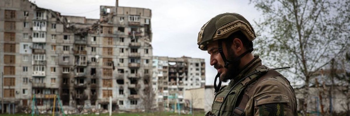 A soldier profiled against a bombed-out building.