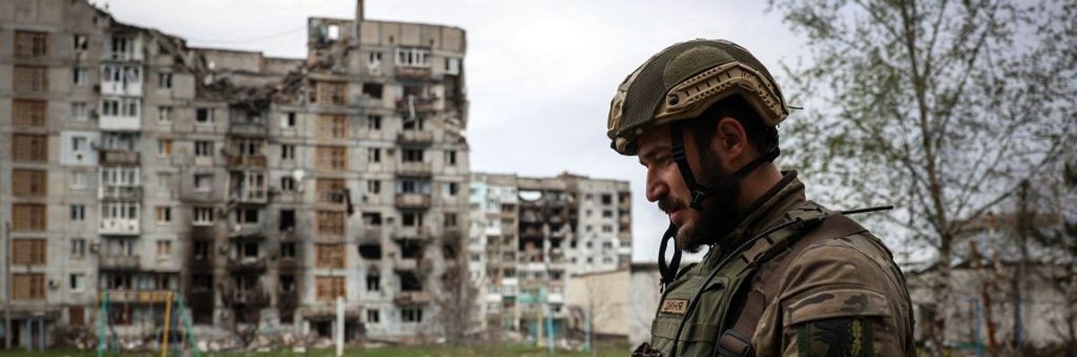 A soldier profiled against a bombed-out building. 
