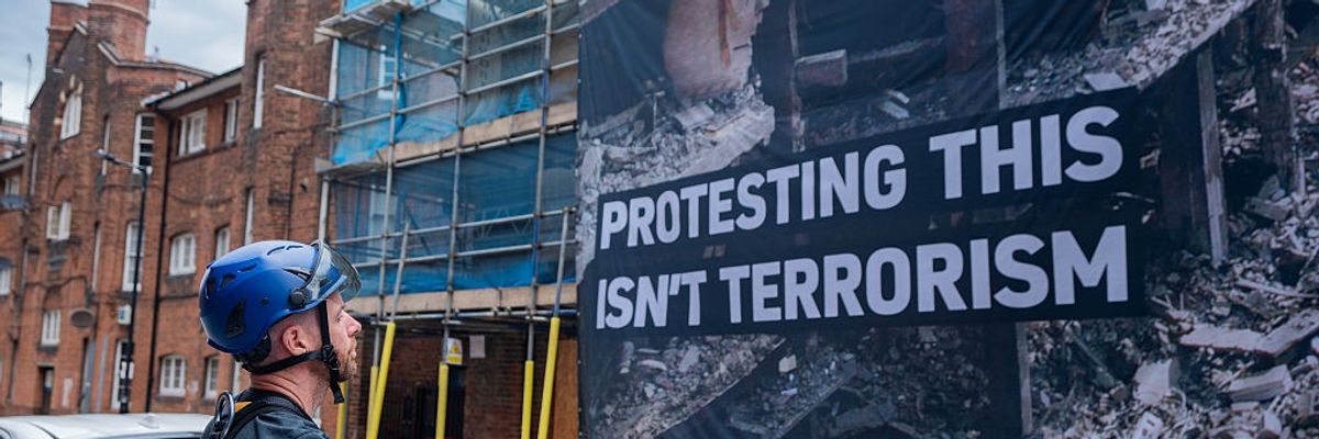 A specialist climbing Policeman surveys a banner in London