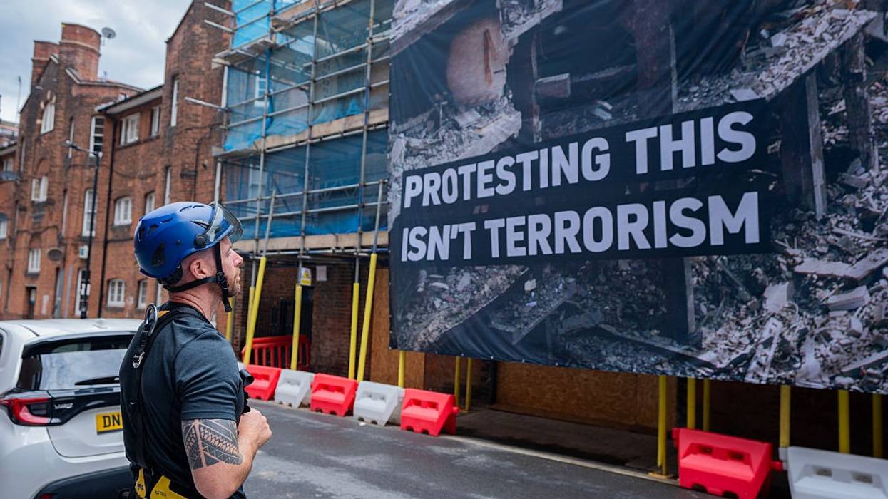 A specialist climbing Policeman surveys a banner in London
