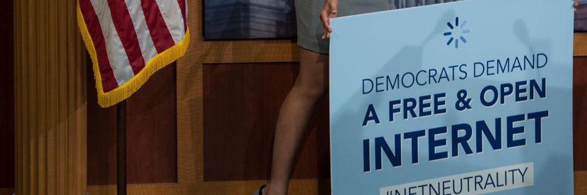 A staffer removes a net neutrality sign after a press conference following the vote that would help stop the Federal Communications Commission's effort to reverse Obama-era regulations on net neutrality May 16, 2018. (Photo: Sarah Silbiger/CQ Roll Call)