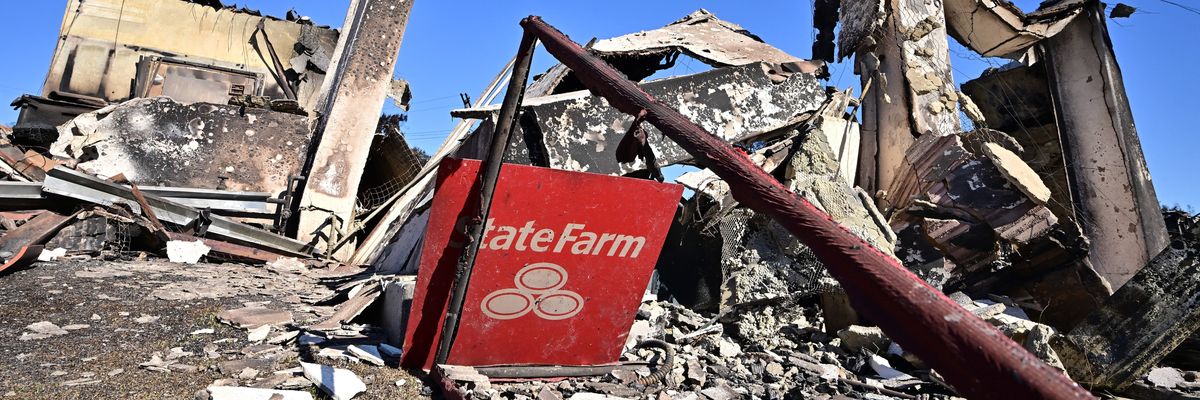 A State Farm insurance company sign sits amid the rubble of a building destroyed by the Palisades Fire