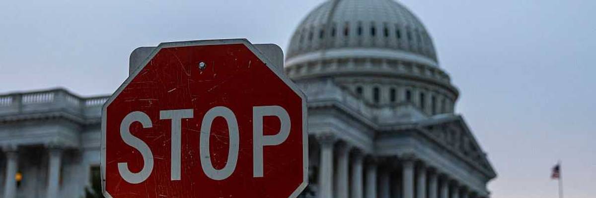 A stop sign in front of the US Capitol.