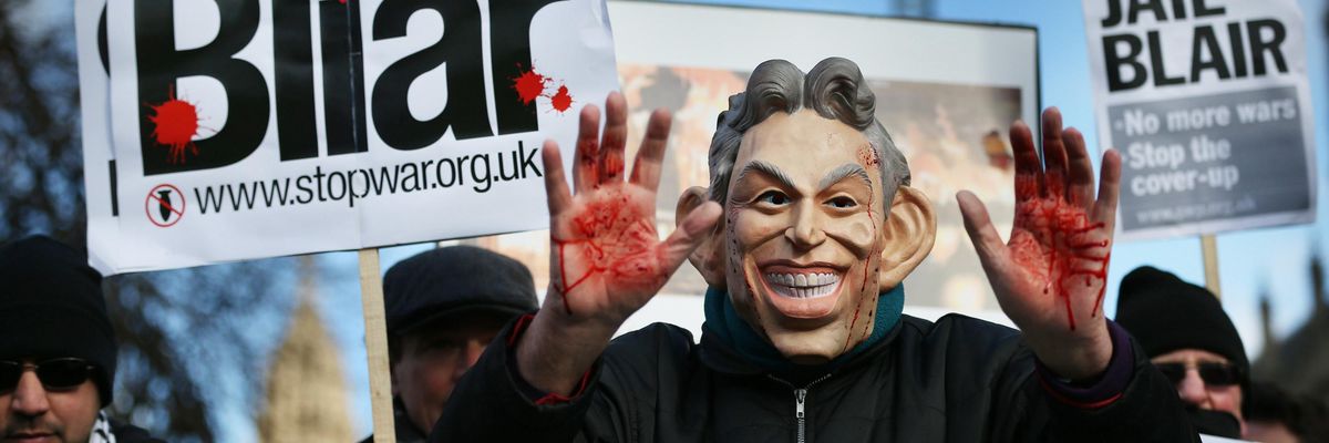 A Stop the War Coalition protester, wearing a mask depicting former Prime Minister Tony Blair, shows bloodied hands near Parliament on January 29, 2015 in London.