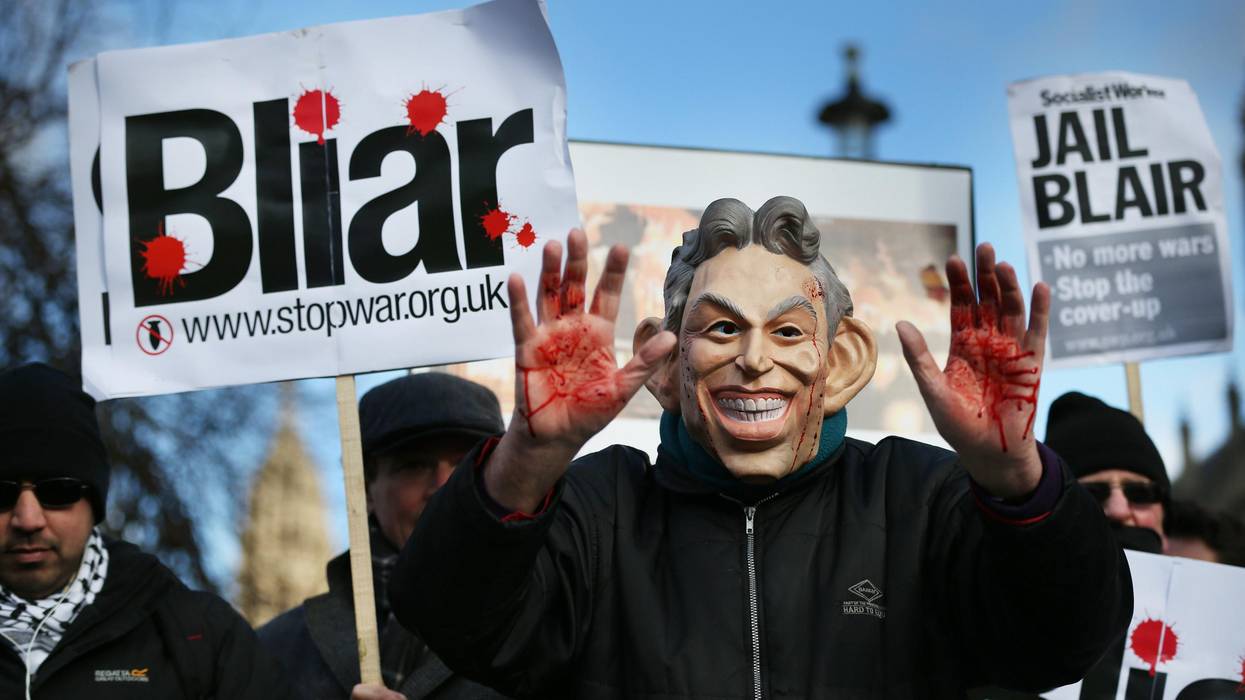 A Stop the War Coalition protester, wearing a mask depicting former Prime Minister Tony Blair, shows bloodied hands near Parliament on January 29, 2015 in London.