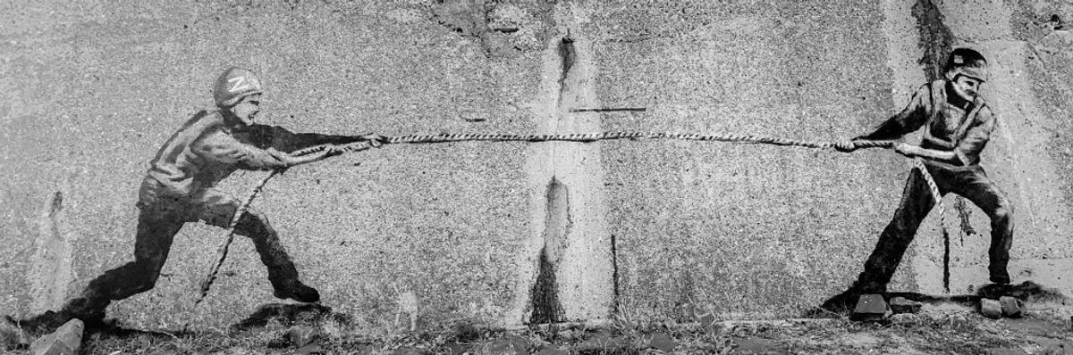 A street art mural depicting a tug-of-war between a Russian and Ukrainian soldier is seen on a war memorial in Izyum