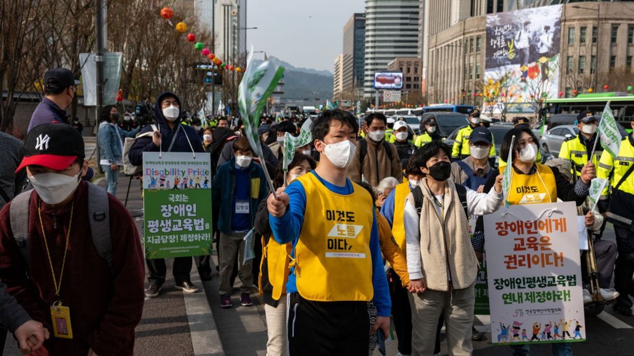 A street in Seoul, South Korea, filled with people marching with signs.