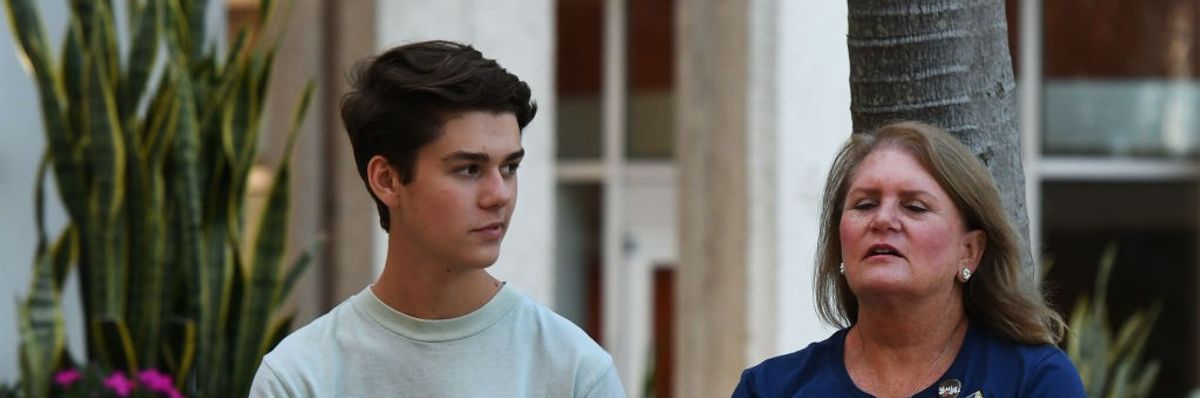 A student holds a placard that says "Protect Us From Fascists"