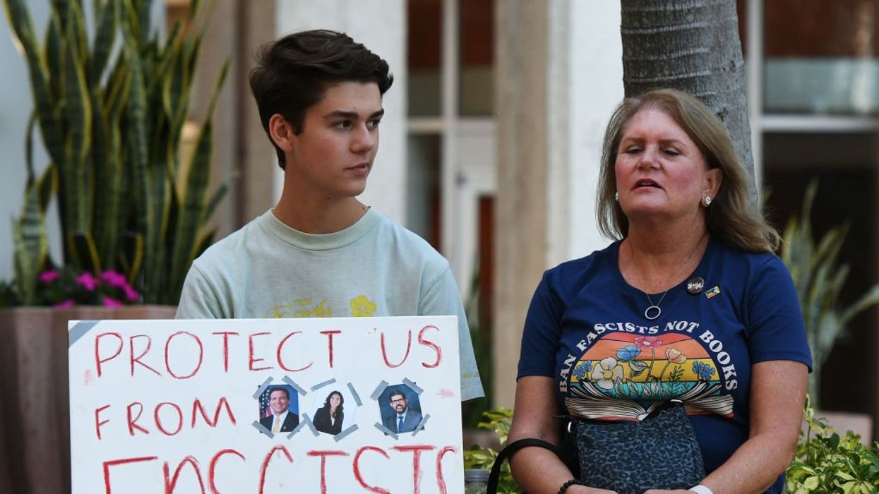 A student holds a placard that says "Protect Us From Fascists"