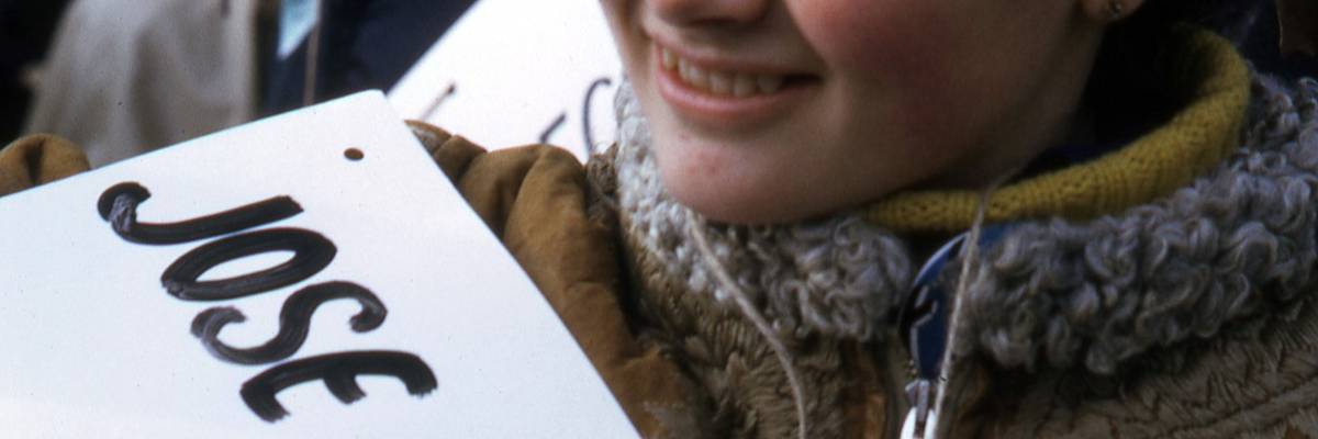 A student holds a sign with the name of a soldier killed during the Vietnam War.