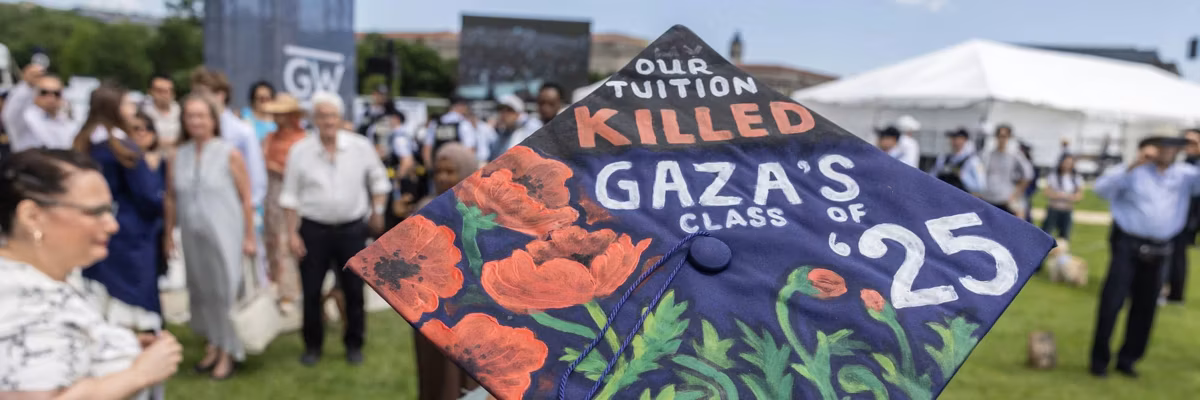A student wearing a graduation cap with the message "Our