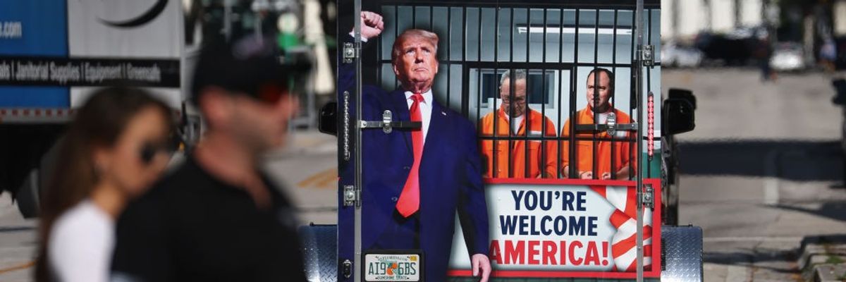 A supporter of former President Donald Trump with sign "You're Welcome America"