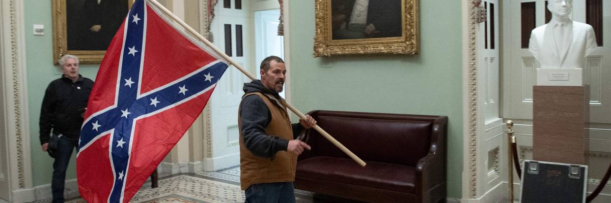 A supporter of US President Donald Trump carries a Confederate flag as he protests in the US Capitol Rotunda on January 6, 2021, in Washington, DC.