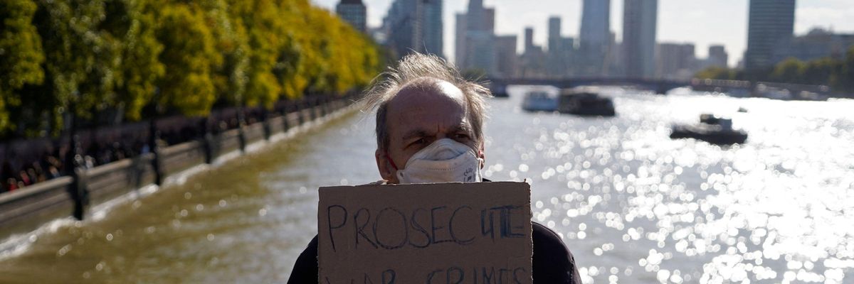 A supporter of WikiLeaks founder Julian Assange holds a placard outside the British parliament in London on October 8, 2022.