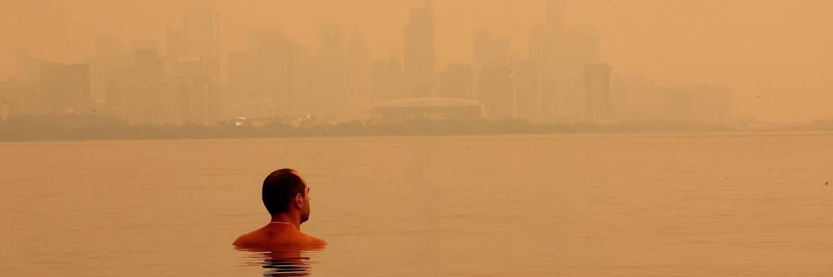 A swimmer checks out the view of the smoke from Northern Ontario wildfires obscuring the Toronto skyline.