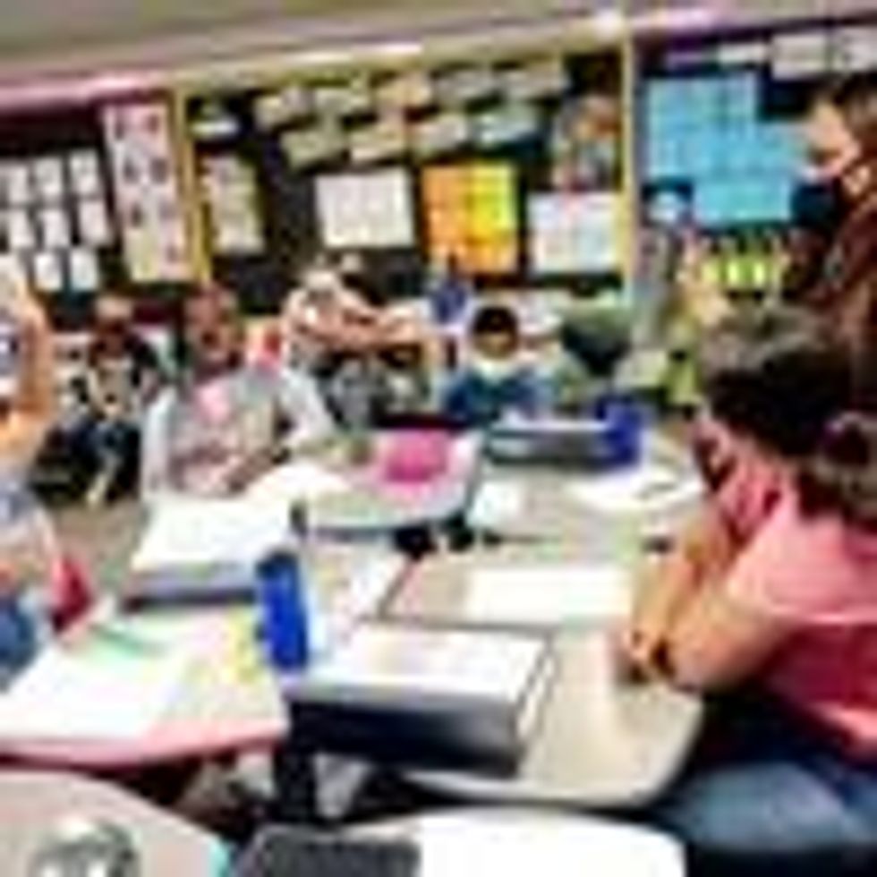 A teacher speaks with 5th grade students