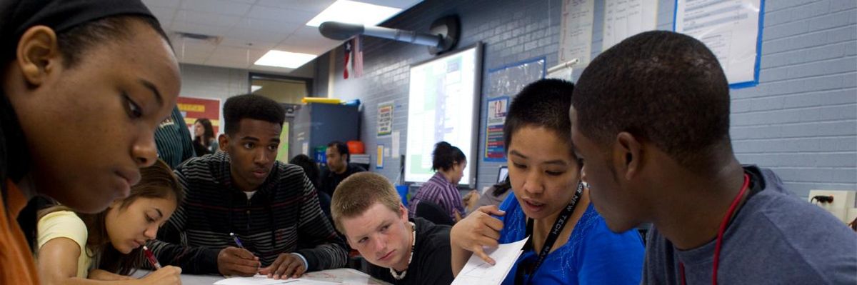 A teacher works with high school students